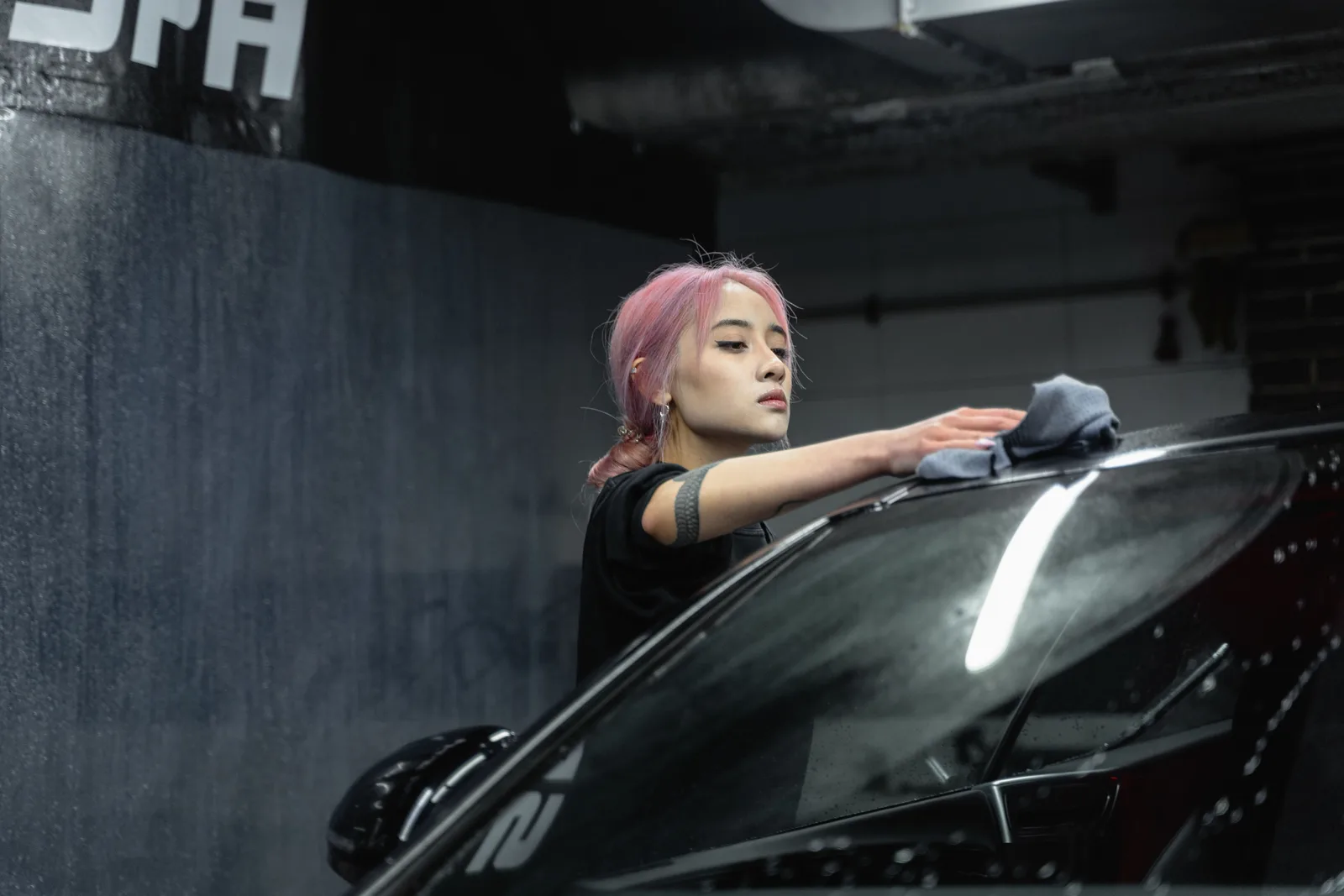 Photo by Tima Miroshnichenko on Pexels A person wipes a car windshield with a cloth.