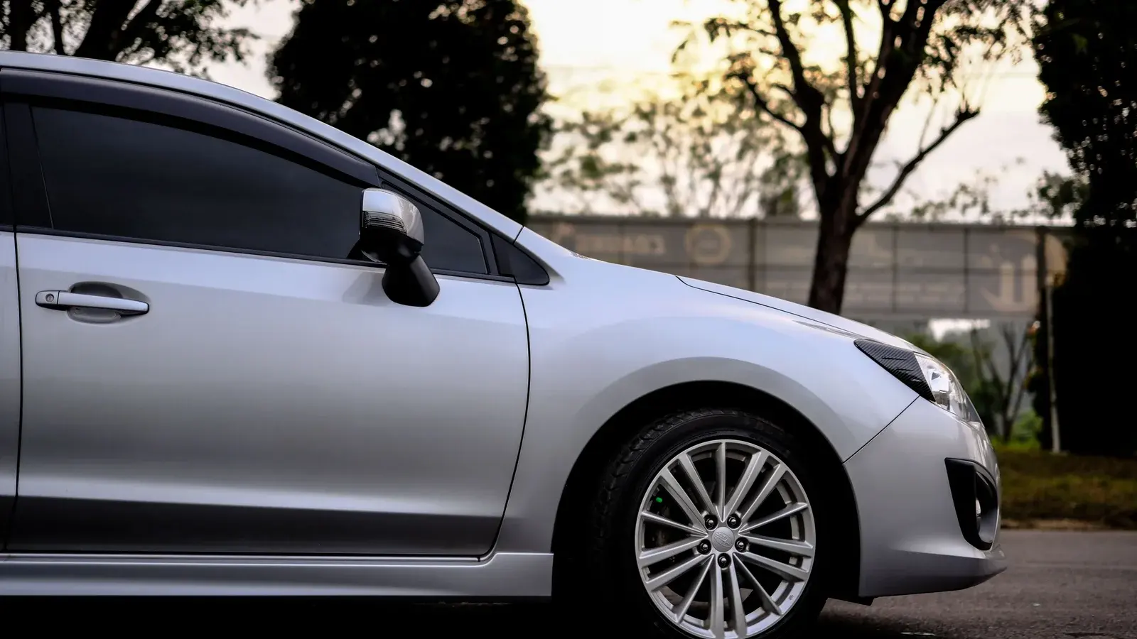 Photo by Ayyeee Ayyeee on Pexels Side windows and front wheel of a parked silver car